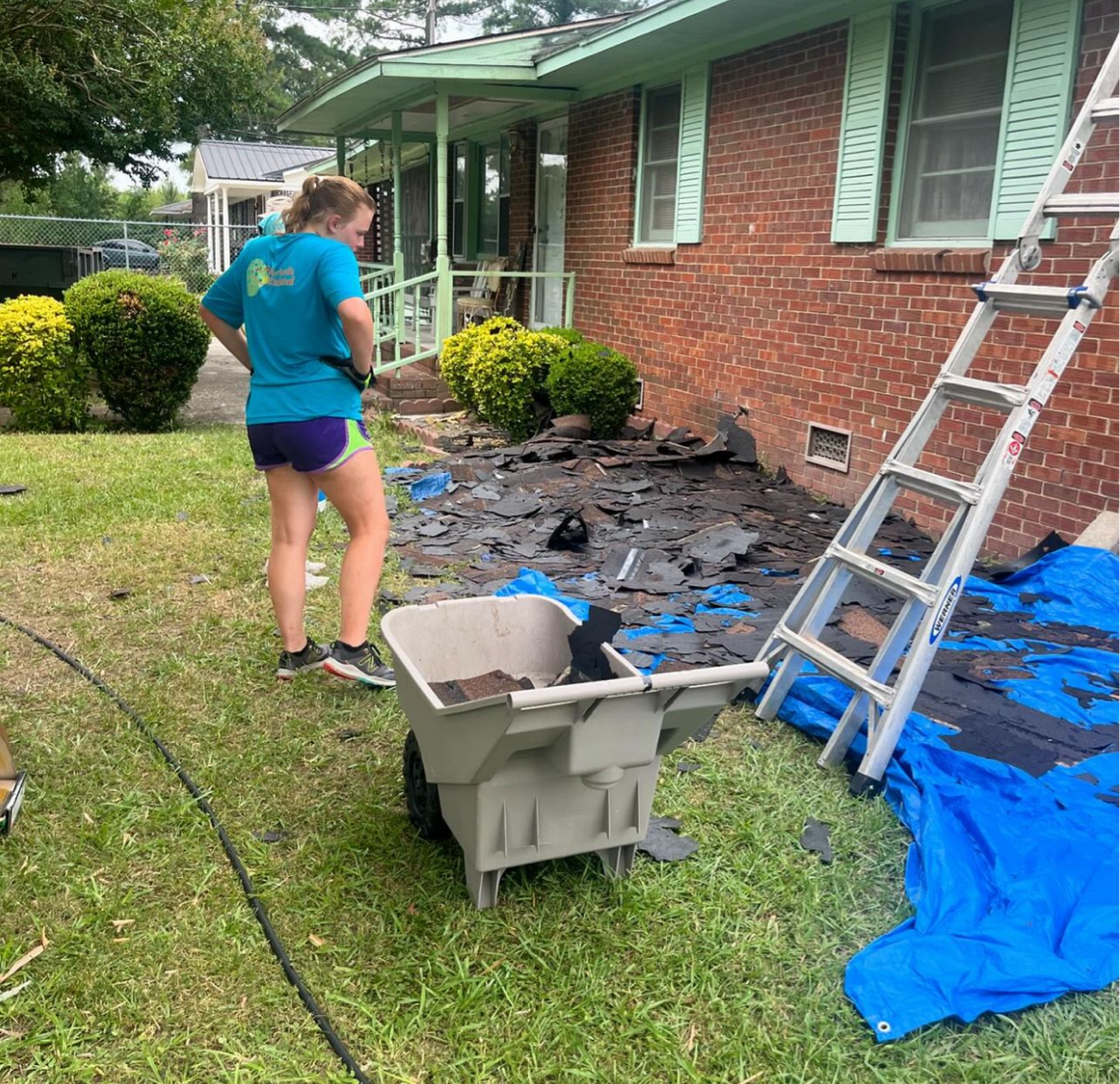 A picture of a Salkehatchie volunteer looking down at debris cleared from a roof.